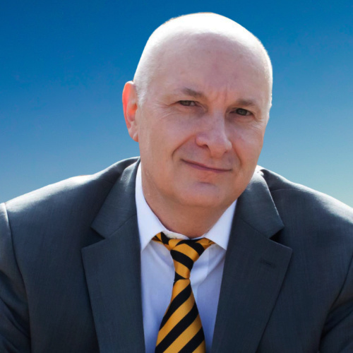 A bald man wearing a suit coat and striped tie